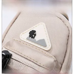 Detail of beige tactical mini pouch featuring a silicone triangular climber patch logo