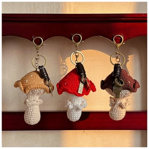 Détail de pendentifs champignons crochetés à la main avec fermoirs en trois couleurs