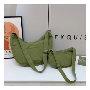 Detail view of two green nylon crescent sling bags in different sizes with adjustable straps