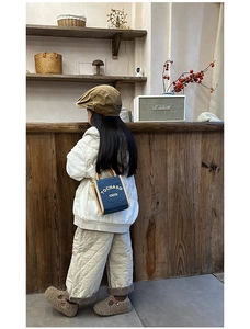 Close-up of kids mini leather crossbody bag with letter detail and metal chain strap