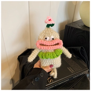 Macro detail of handmade crochet bag with quirky face design and green ruffles
