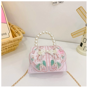 Détail du sac brodé rose pour fille avec poignée en perles et chaîne dorée fine