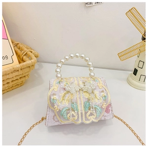 Détail du mini sac à bandoulière rose avec poignée en perles et broderies florales dorées