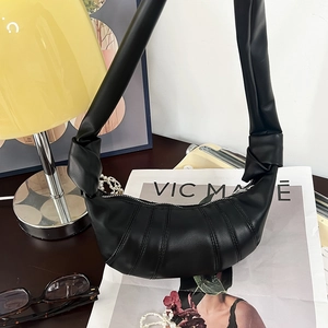 Detail der schwarzen Croissant-Tasche aus gefaltetem PU-Leder in minimalistischer Form