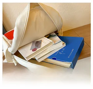 Top view showing the large internal capacity of the white backpack filled with books