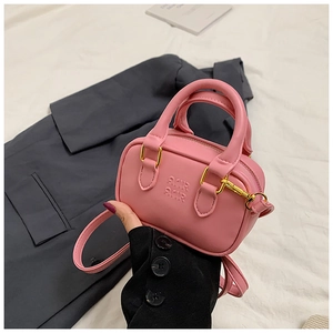 Detail der rosa Mini-Boston-Tasche mit geprägten Buchstaben und goldener Hardware