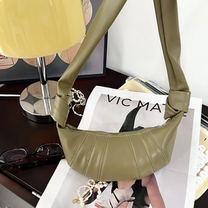 Detail der olivgrünen Croissant-Tasche mit Knotengurten und plissierter Textur