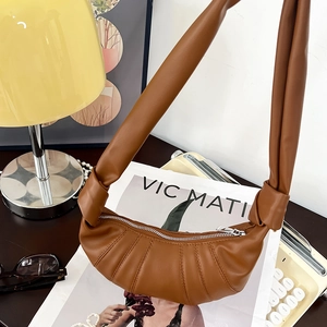 Detail der Crossbag aus Leder in Karamell mit Falten-Design und geknotetem Schultergurt