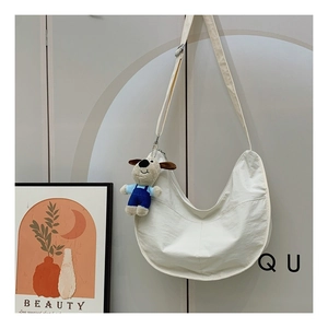 Detailed shot of white crescent shoulder bag with cute puppy plush charm accessory