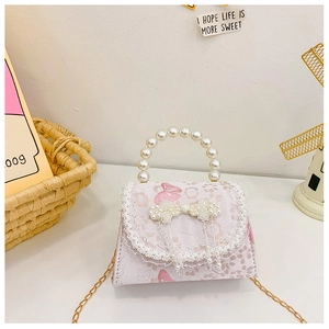 Détail du sac floral pour fille avec poignée en perles, dentelle et nœud brillant