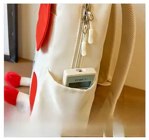 Detail view of the canvas backpack side pocket with red heart accent and mesh straps