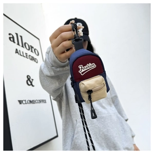 Close-up of mini backpack coin purse with Fashion embroidery and colorful canvas panels