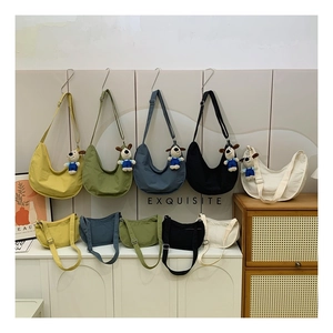 Detail showing various sizes and colors of minimalist crescent bags with plush charms