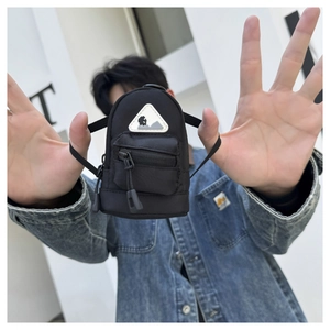 Detailed macro of black mini utility pouch with double zipper and mountain badge