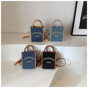 Close-up of four stylish mini denim crossbody bags with gold TOCHASO CUTE lettering