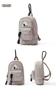 Detailed views of a khaki mini utility pouch with a mountain patch and black carabiner