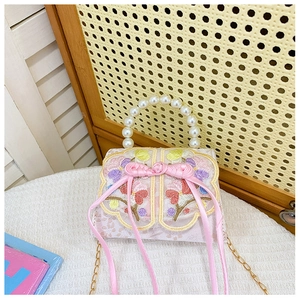 Détail du sac brodé rose pour fille avec poignée en perles et nœud en ruban