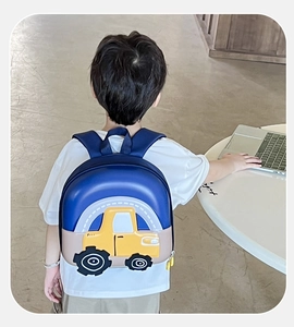 Detail view of child wearing a blue car shell backpack with adjustable shoulder straps