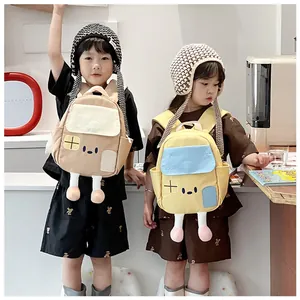 Close-up of cute house-shaped backpacks for kids with cartoon 3D doll legs and windows