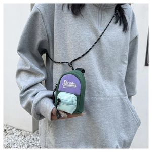 Close-up of a mini tricolor neck pouch with woven lanyard on a grey hoodie