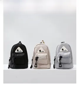 Mini nylon utility pouch charms in black, cream, and grey with mountain logo detail