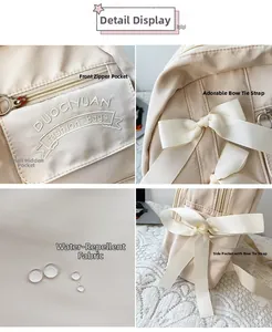 Dettaglio dello zaino in nylon crema con fiocco decorativo e tessuto idrorepellente