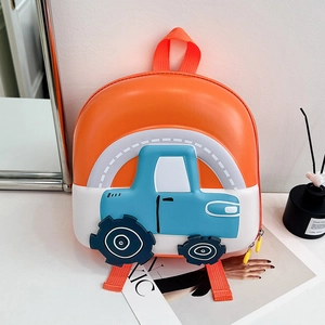 Detail of waterproof hard shell children backpack with 3D cartoon truck design on table