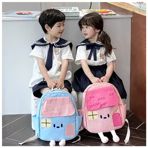Cute house-shaped kids backpacks in blue and pink with 3D details on young models