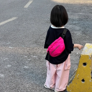 Sac de poitrine rose minimaliste pour enfants avec bretelles noires sur un jeune modèle