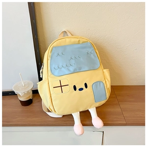 Detail showing cartoon house-shaped kid's backpack with yellow body and blue flap