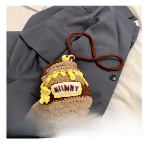 Gros plan détaillé du mini sac en crochet fait main en forme de pot de miel avec abeilles