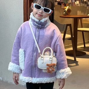 Mädchen im lila Wildleder-Lammfellmantel mit Mini-Handtasche und braunem Bärenanhänger