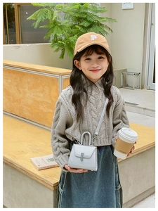 Kids streetwear style with grey knit sweater, blue jeans, and silver glitter crossbody bag