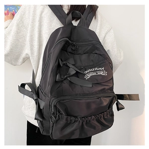 Vista laterale dello zaino scolastico in nylon nero con fiocco e tasche sul modello