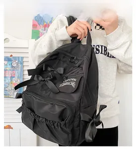 Dettaglio dello zaino in nylon nero impermeabile con decorazioni eleganti con fiocchi di seta