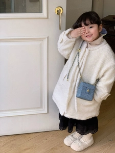 Blue tweed mini box bag with golden chain strap worn by a child in a cozy indoor setting