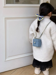 Close-up of a mini denim box bag for kids with gold floral clasp and chain strap