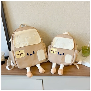 Detailed comparison of cartoon house backpacks in two sizes on a wooden shelf