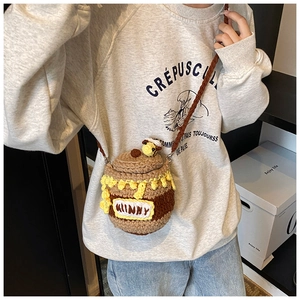 Détail d'un sac bandoulière en crochet fait main en forme de pot de miel avec abeille