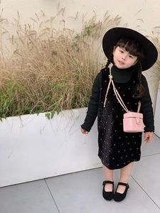 Pink quilted chain crossbody bag styled with a girls black velvet dress and felt hat