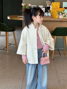 Détail d'une veste chinoise pour enfant avec boucles et petit sac à main rose