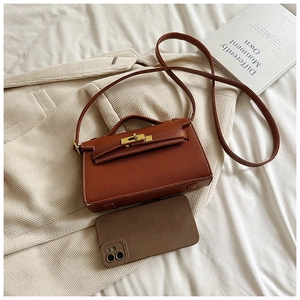 Mini sac bandoulière marron pour enfants comparé à un smartphone pour la taille