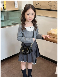 Detail view of a black shiny PU leather mini crossbody bag for girls with vintage school style