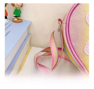 Détail du sac à paillettes avec bandoulière arc-en-ciel et sequins violets brillants
