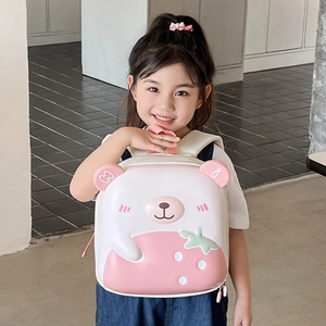 Cute pink cartoon bear strawberry hard shell EVA backpack for kids being worn by a child