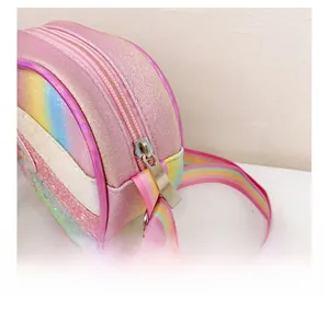 Détail de la fermeture éclair argentée et sangle arc-en-ciel sur sac enfant rose