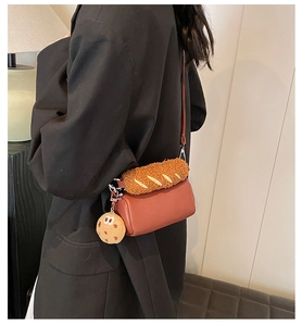 Vue détaillée d'un sac cylindre rétro rouge-brun avec un porte-clés biscuit peluche