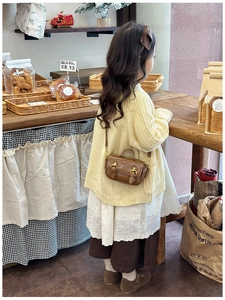 Retro brown oil wax leather mini crossbody bag shown on a child in a cafe setting