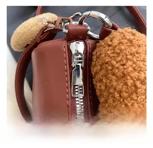 Détail de la fermeture éclair en métal argenté et bordure en fausse fourrure marron