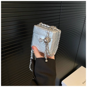 Detail of silver metallic mini box bag featuring quilted pattern and flower clasp